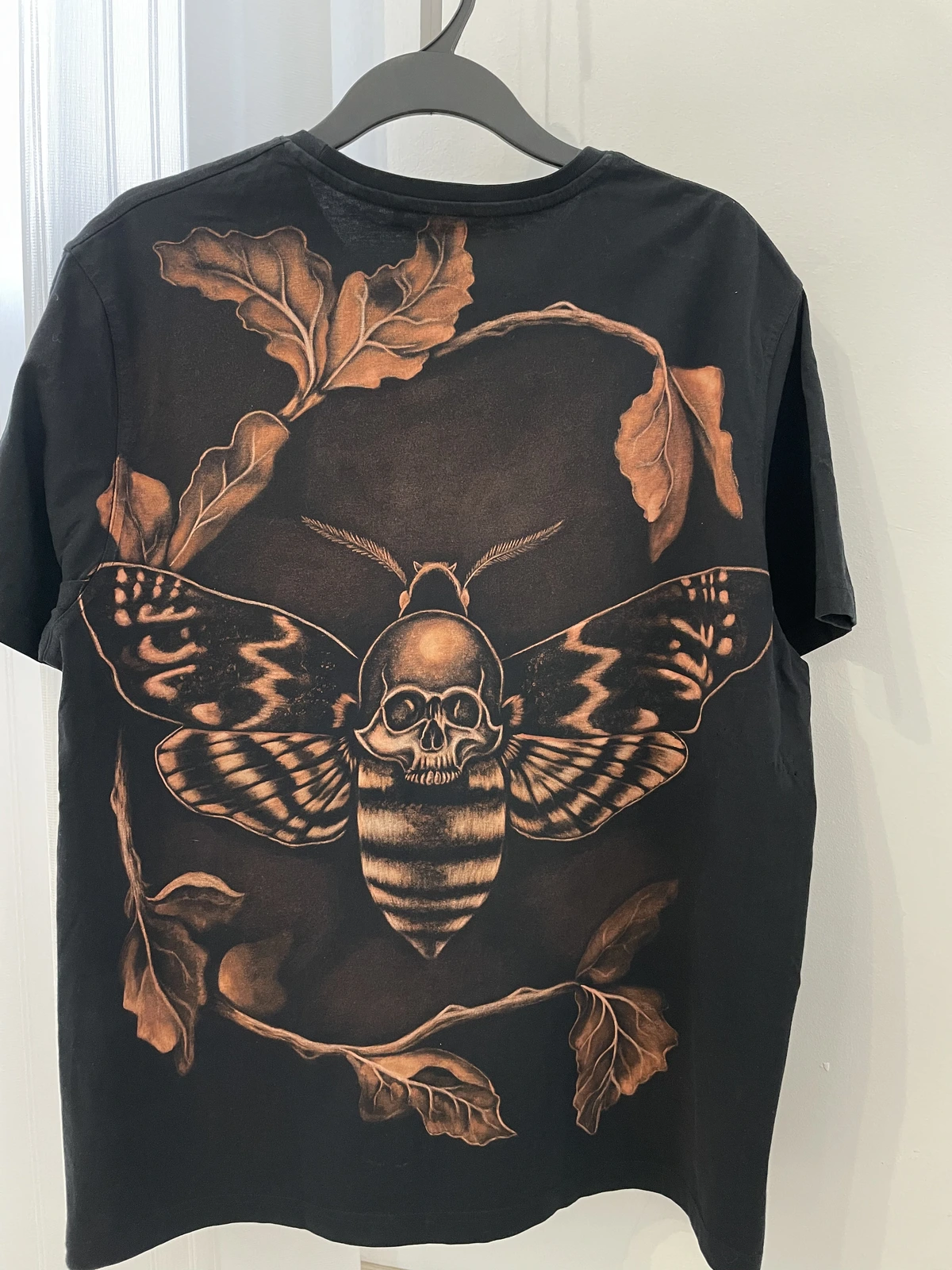 Death's-head hawk moth bleach shirt design hand-painted on a black T-shirt
