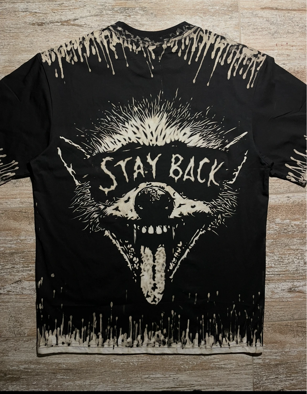 Funny raccoon bleach shirt design with Stay Back lettering on a black T-shirt