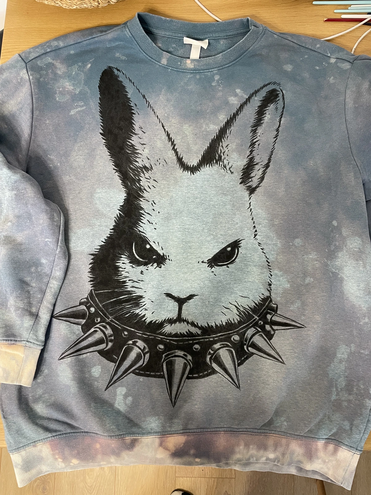 Hand-painted angry bunny artwork on distressed blue sweatshirt