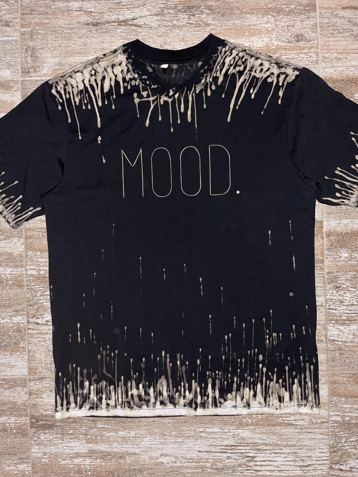 Minimal MOOD typography bleach shirt design with artistic bleach drips on black fabric