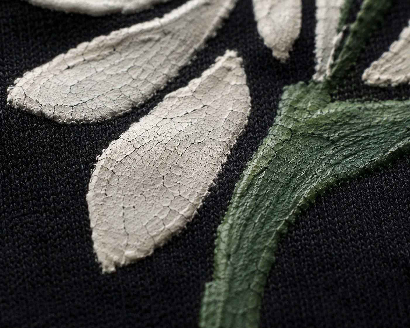 Stiff fabric paint texture on folded black hoodie