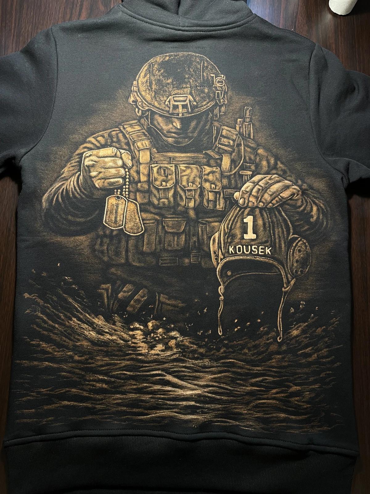 Rückansicht eines schwarzen Hoodies mit einem Bleach-Art-Motiv, auf dem ein Soldat mit Erkennungsmarken und einer Wasserballkappe abgebildet ist.