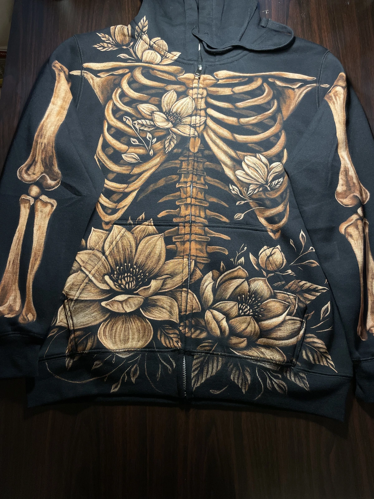 Skeleton and magnolia bleach art zip hoodie on black fabric