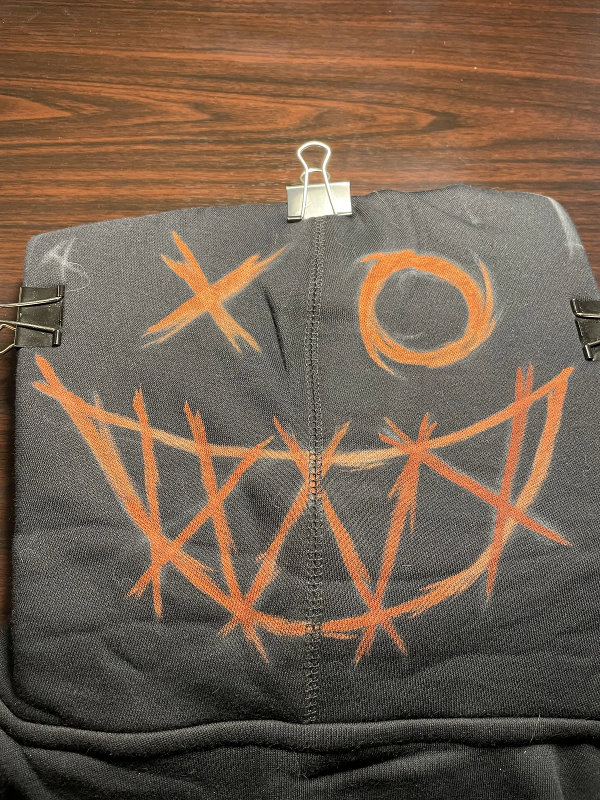 Artist painting custom bleach art design on hoodie hood