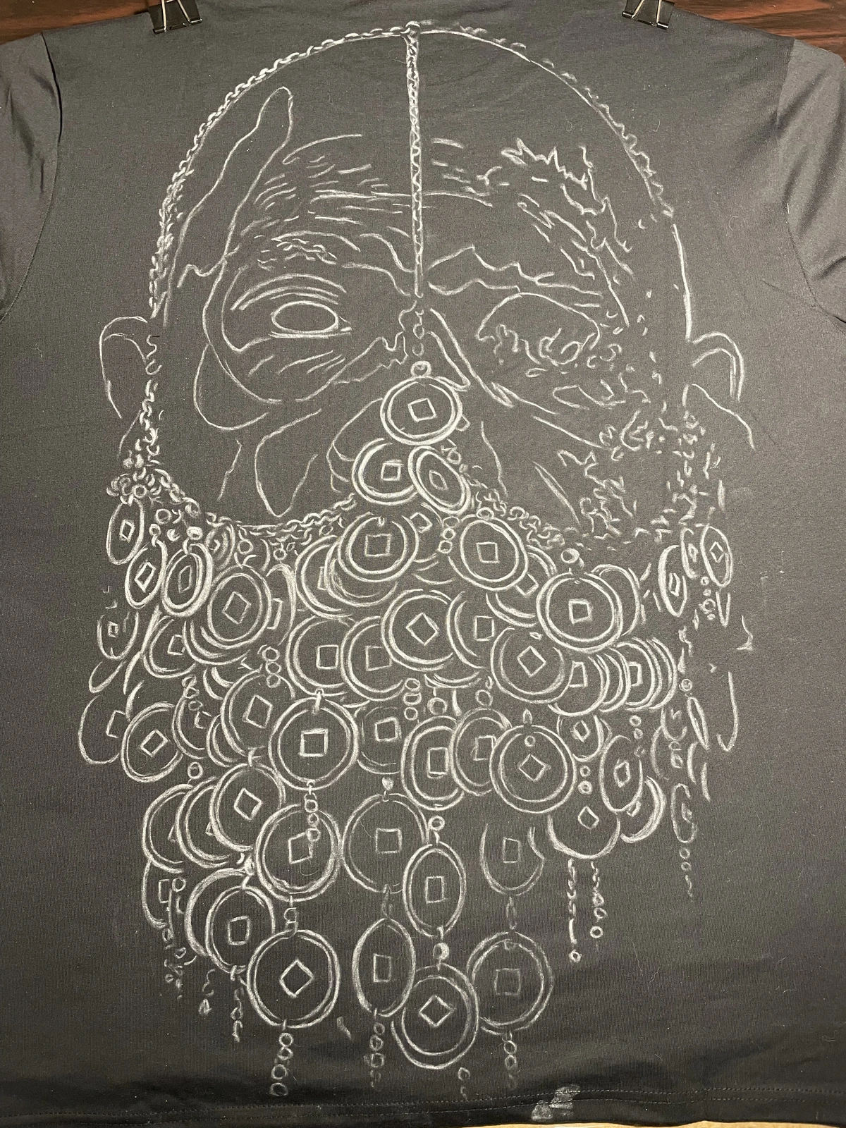 Chalk outline before bleach painting on black clothing