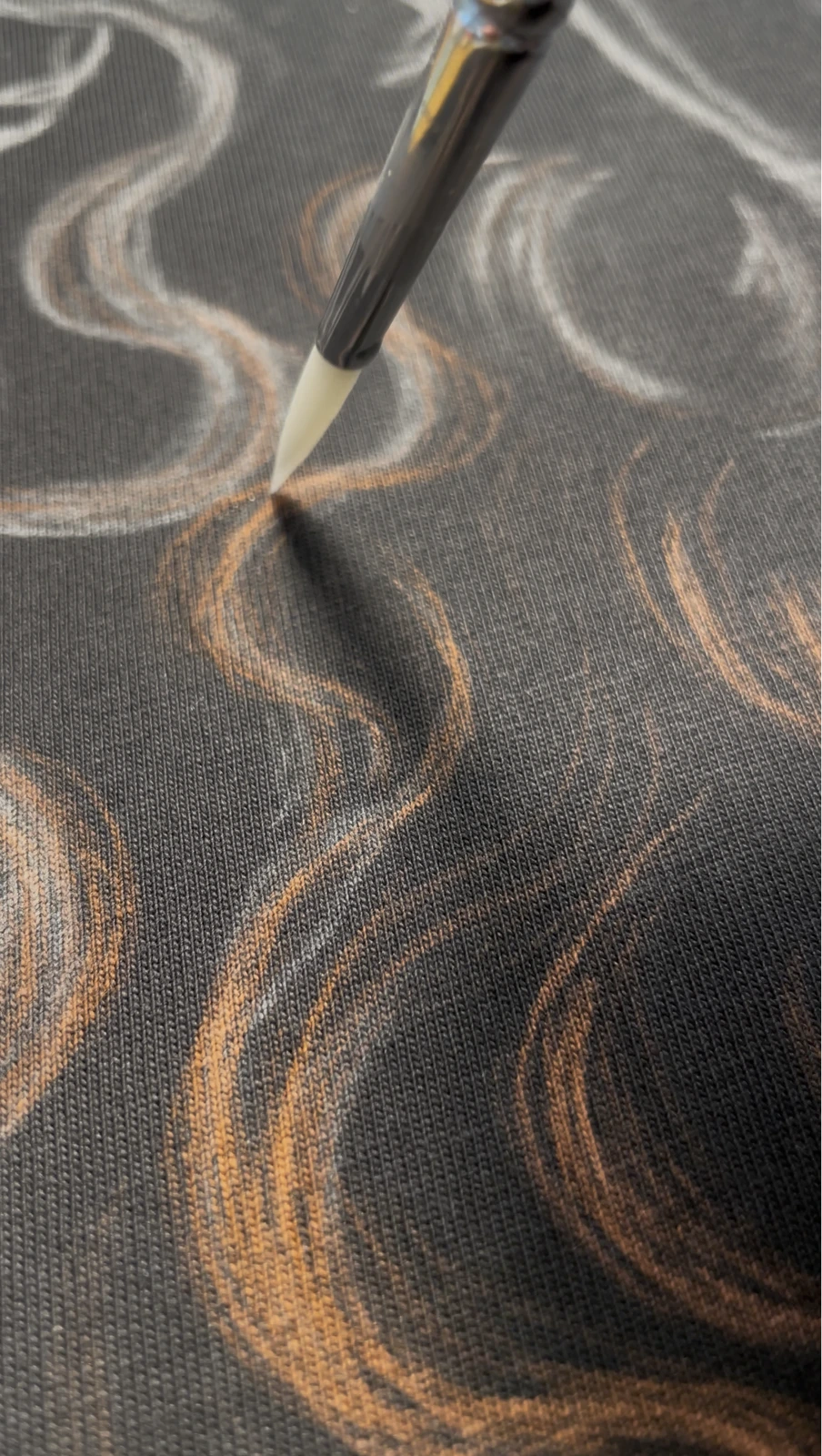 Hand painting custom bleach clothing with bleach and fine brush