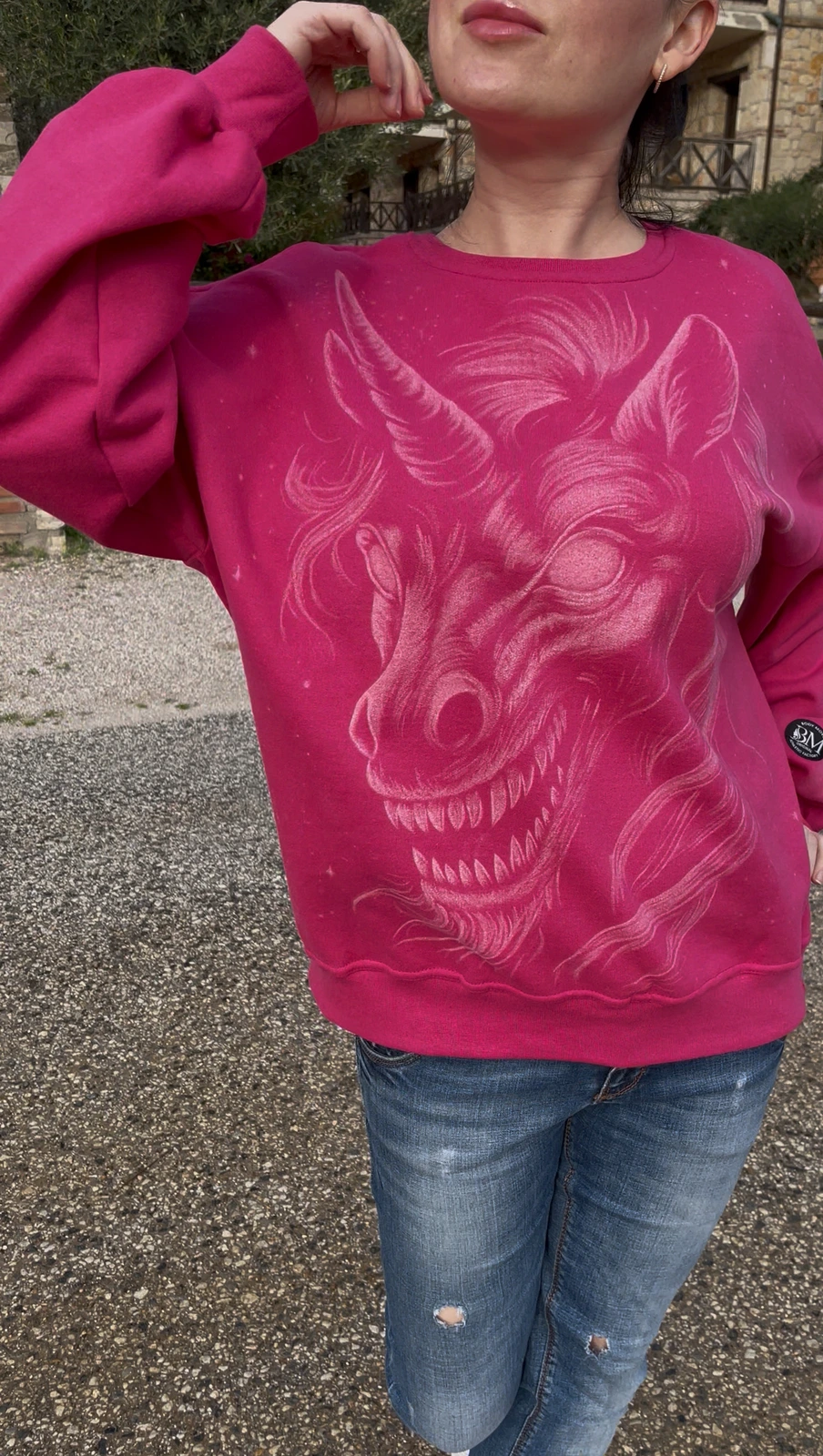 Künstlerin trägt handbemaltes rosa Sweatshirt