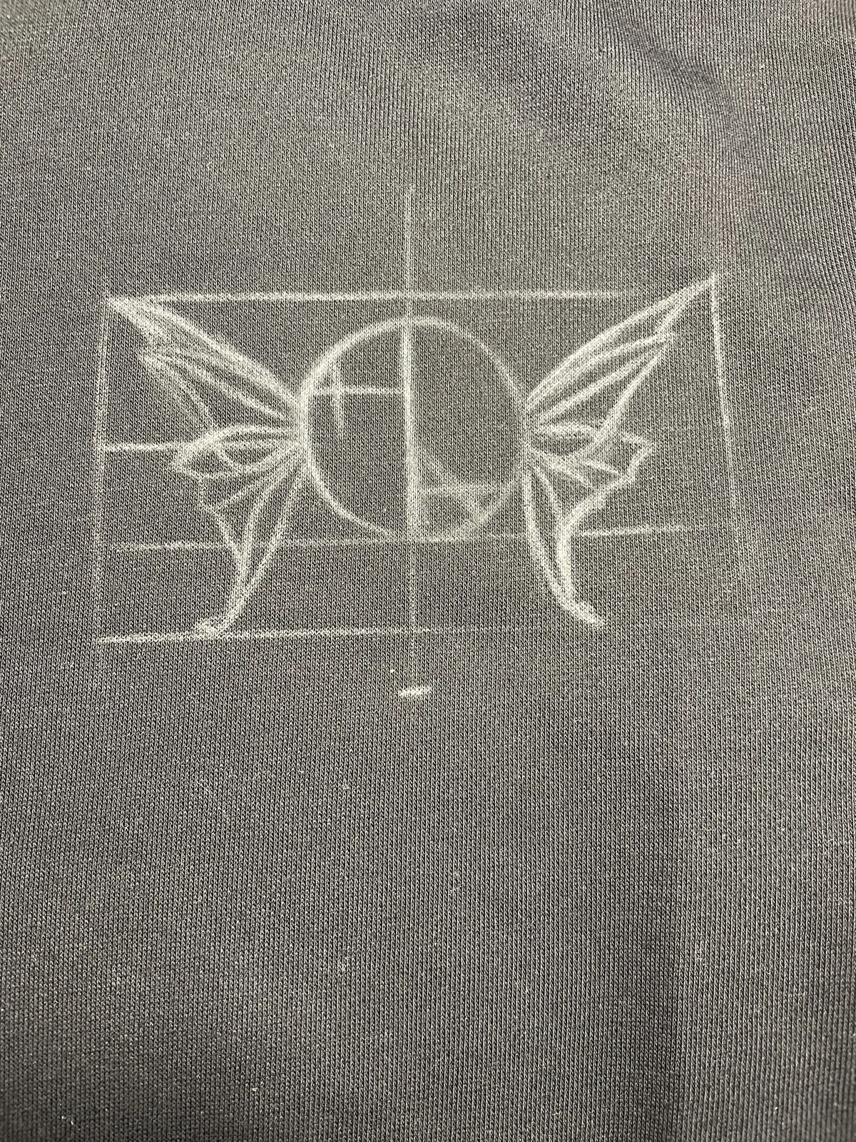 Kreideskizze des Helen Oben Art Logos auf der Vorderseite eines Hoodies