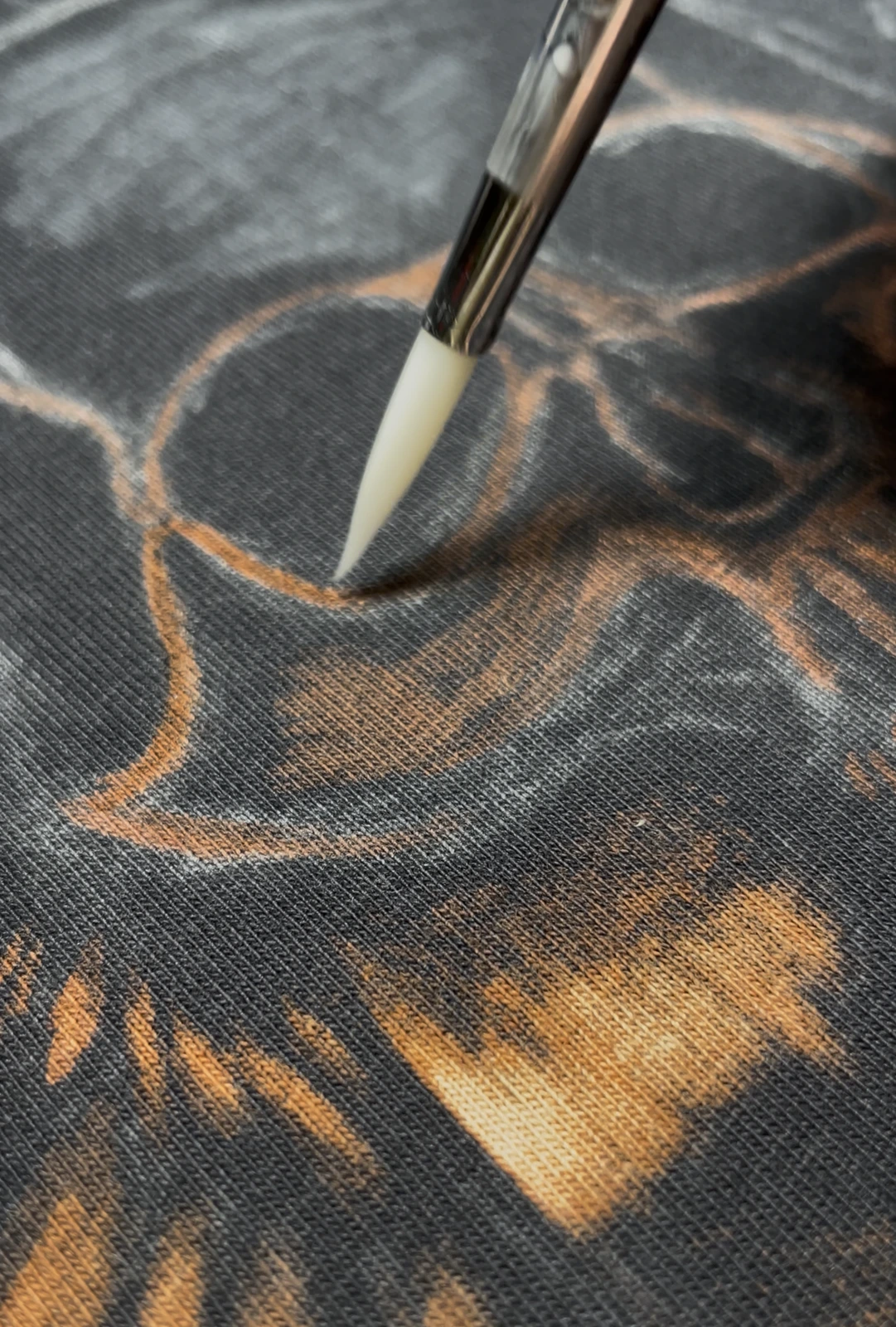 Bleach reaction developing on black cotton fabric