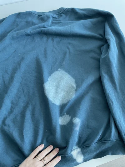 bleach stain on blue sweatshirt before fixing damage