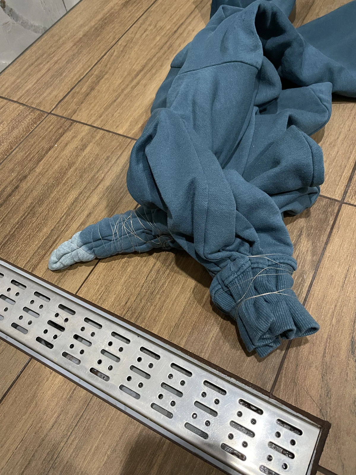 blue sweatshirt before applying bleach in bathroom