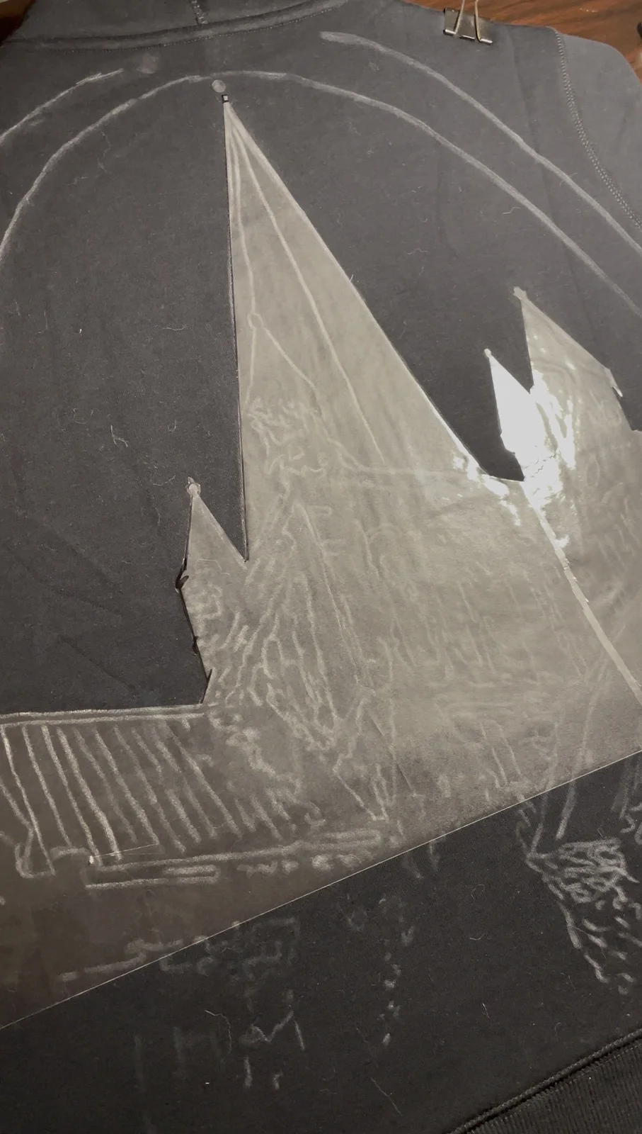 Dark shirt prepared for bleach art on a flat surface