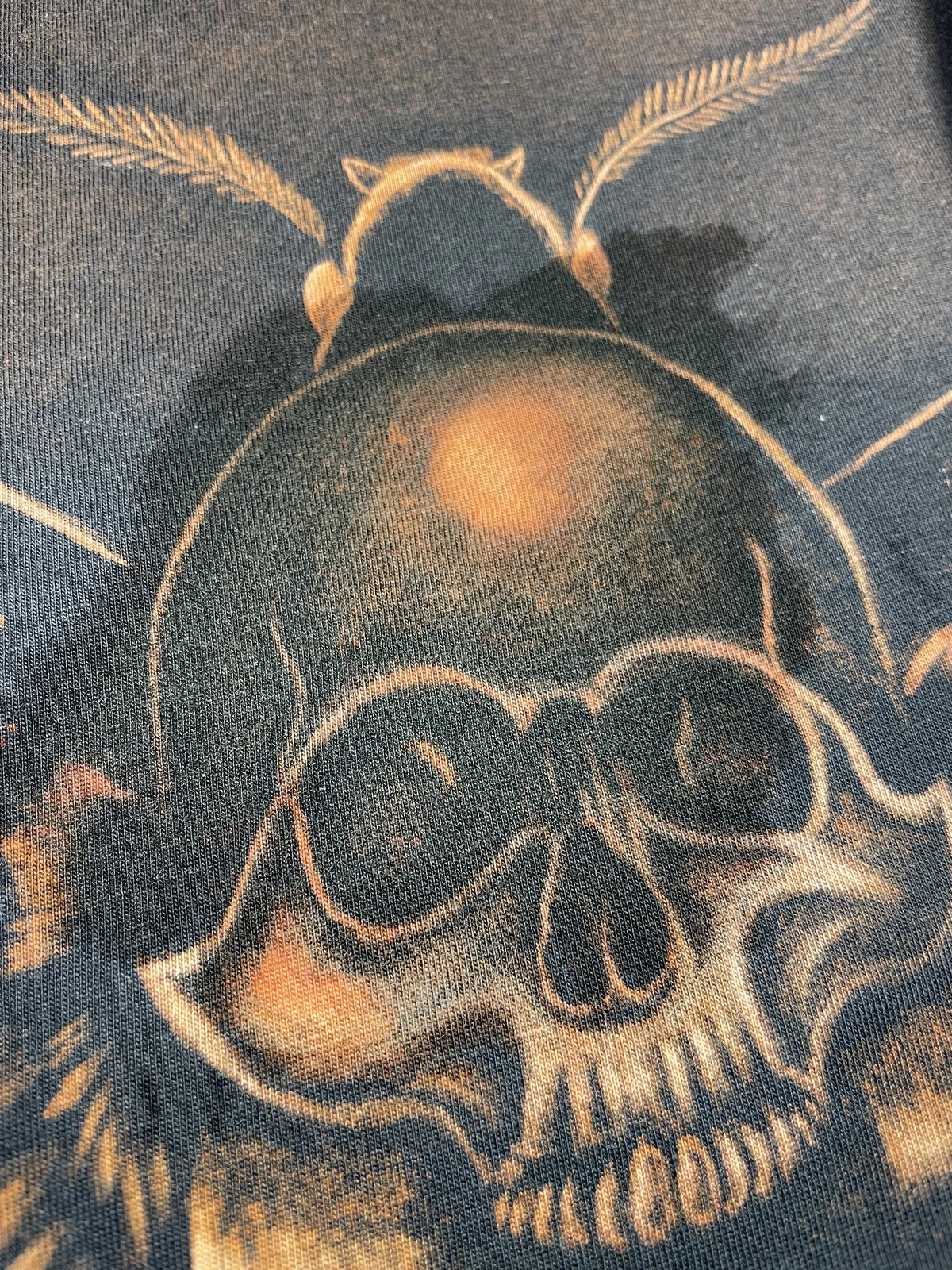 Close-up bleach art reaction on black cotton fabric