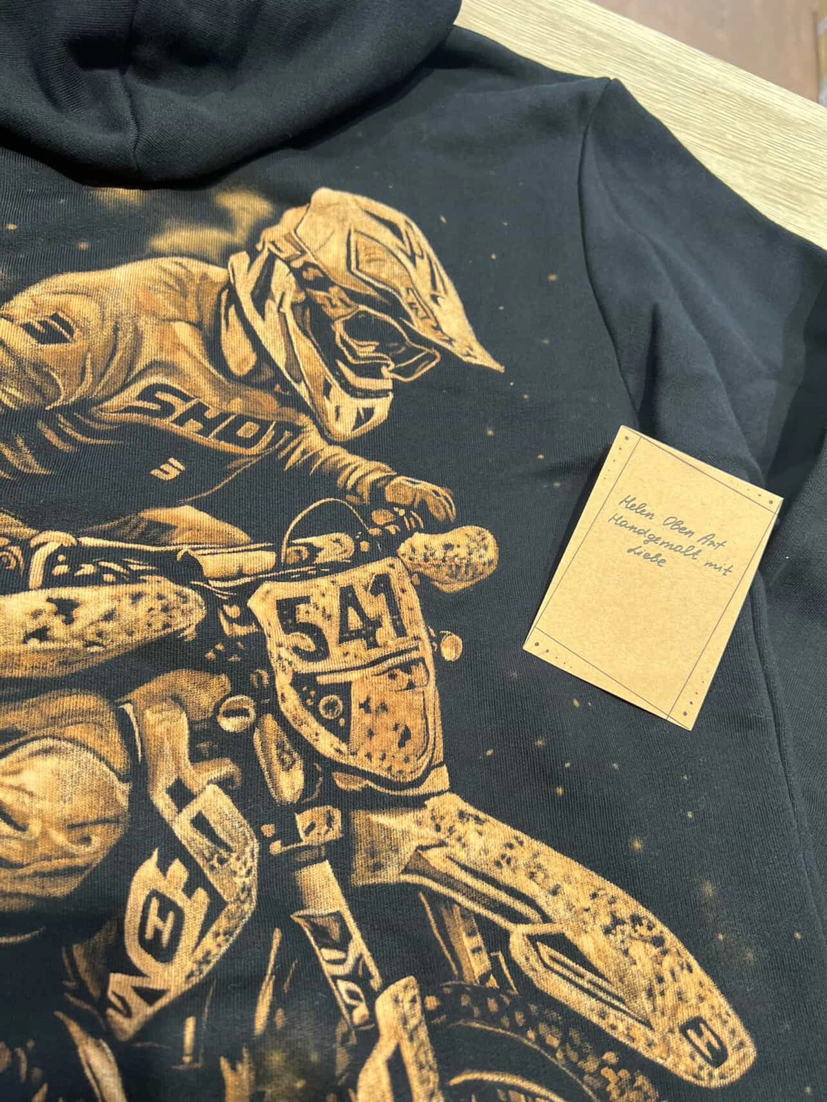 customer wearing handmade hoodie with care instruction card