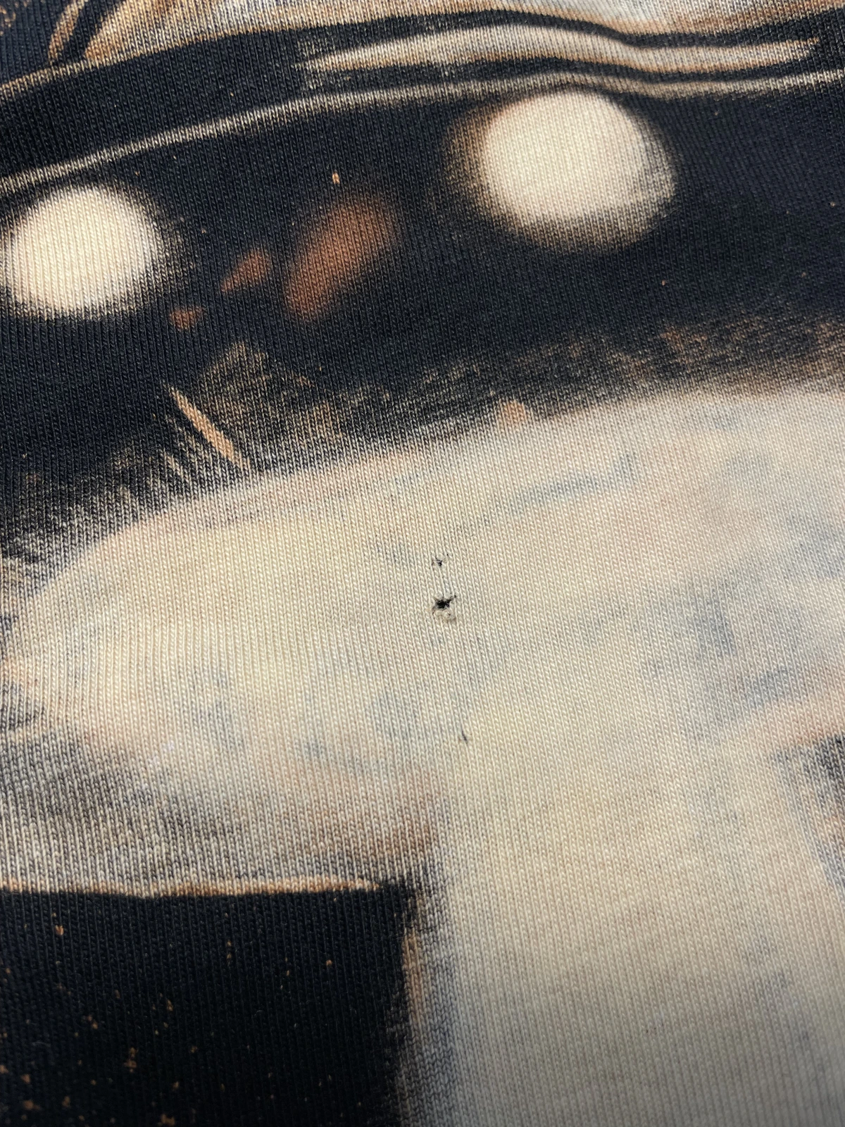 Beschädigtes Bleach Art T-Shirt mit geschwächtem Stoff durch falsches Waschen und Hitze