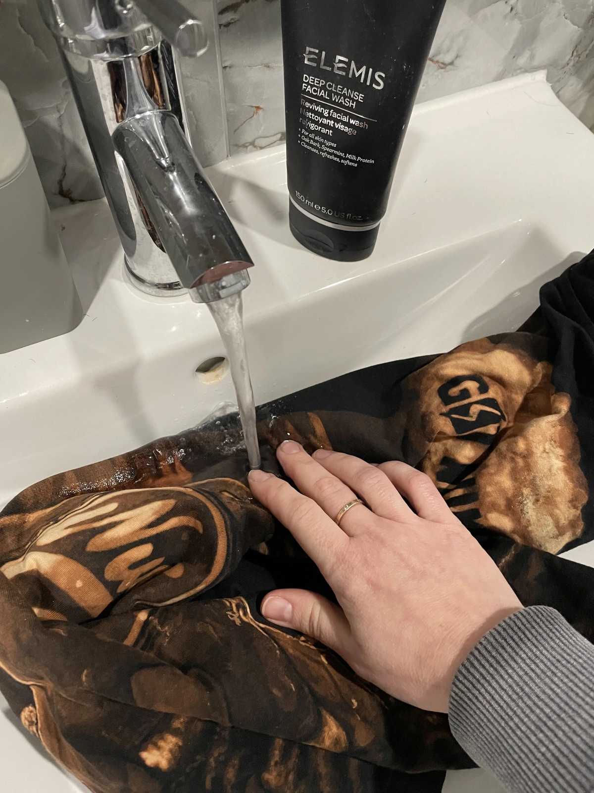 Gebleichtes T-Shirt nach dem Bleach Art Prozess unter kaltem Wasser ausspülen
