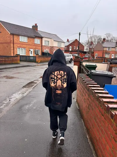 Customer photo wearing a custom hand-painted hoodie with a Sleep Token–inspired design during a walk outdoors