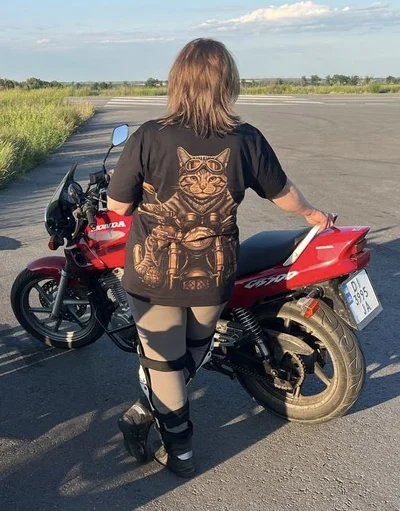 The back of the custom bleach art T-shirt features a biker cat riding a Honda motorcycle, hand painted with bleach on black fabric. A fun, one-of-a-kind design made for a true motorcycle enthusiast.