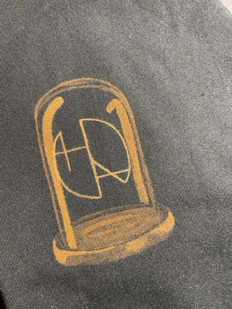 Front view of a t-shirt with the Helen Oben Art logo