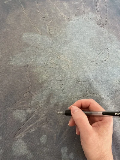 Sketch process of angry bunny textile painting on distressed blue pullover