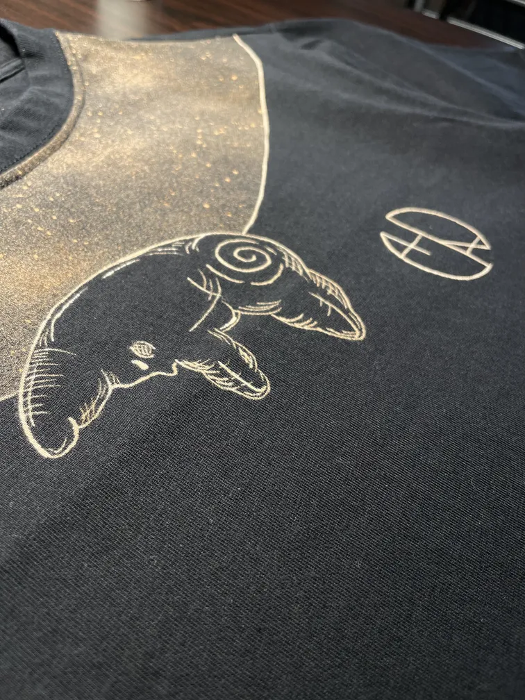 Close-up of a celestial line art logo with moon and star details on a t-shirt