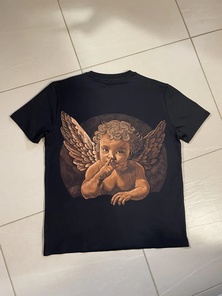 Cherub bleach art illustration covering the back of a black t-shirt