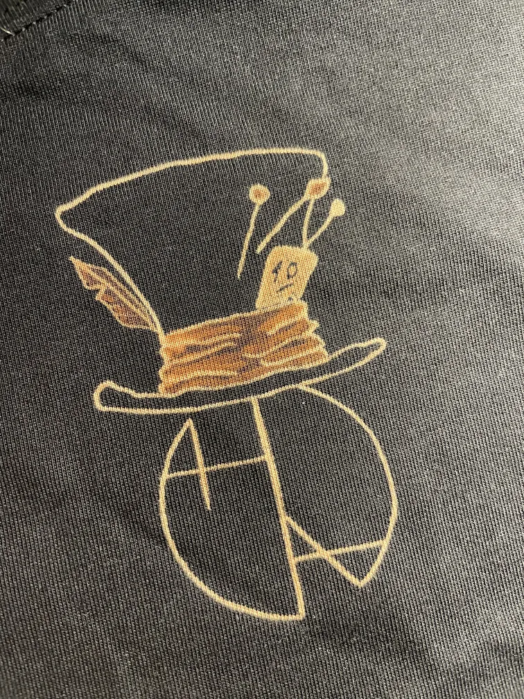 Close-up of the Helen Oben Art logo on the front of the t-shirt