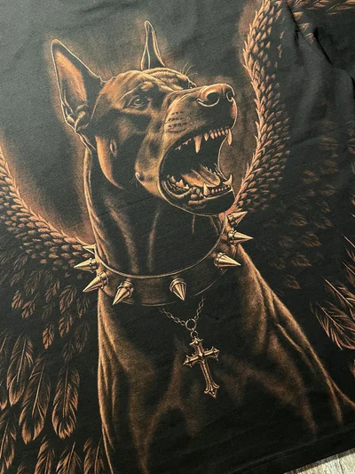Close-up of the hand-painted Doberman with a spiked collar and angel wings on a black T-shirt