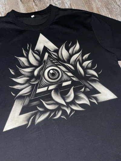 Nahaufnahme des Allsehenden Auges im Dreieck als Bleach Art auf schwarzem T-Shirt