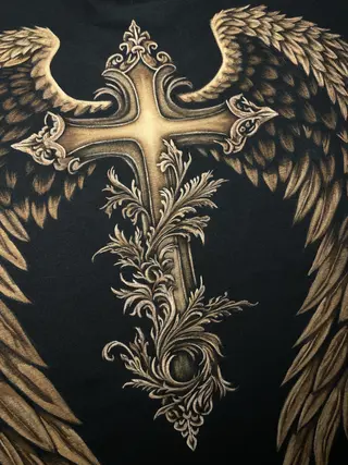 Detailaufnahme eines ornamentalen gotischen Kreuzmotivs mit Flügeln in Bleach-Art-Technik