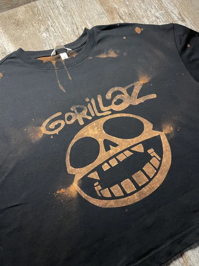 Schräge Vorderansicht des schwarzen Gorillaz Crop Tops mit gebleichtem Logomotiv