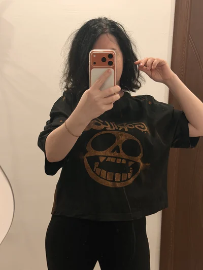 Vorderansicht eines Models im schwarzen Gorillaz Oversize Crop Top mit gebleichtem Logomotiv