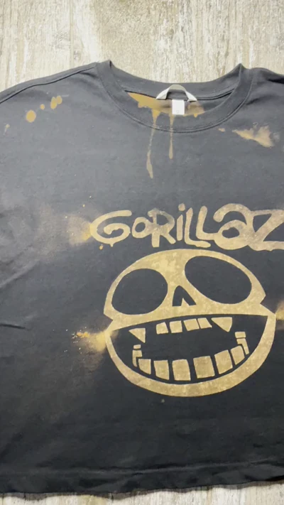 Video des gebleichten Gorillaz Totenkopf Logos und Bandnamens auf der Vorderseite des schwarzen Crop Tops