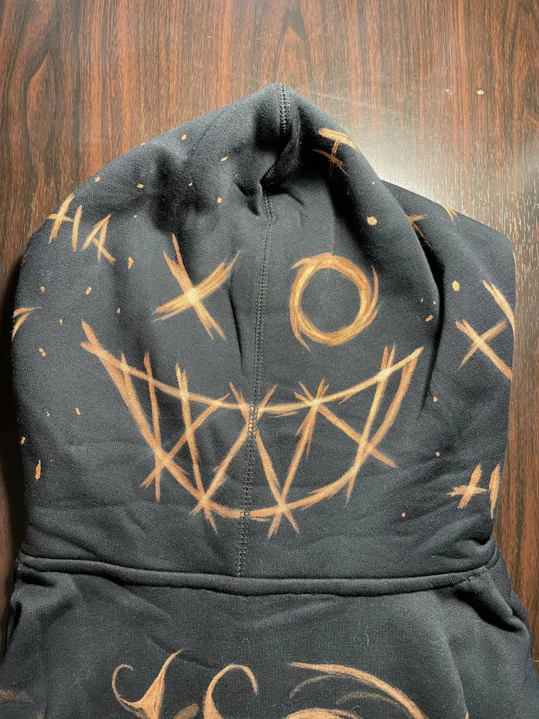 Close-up of a chaotic smile illustration on the center of a hoodie hood