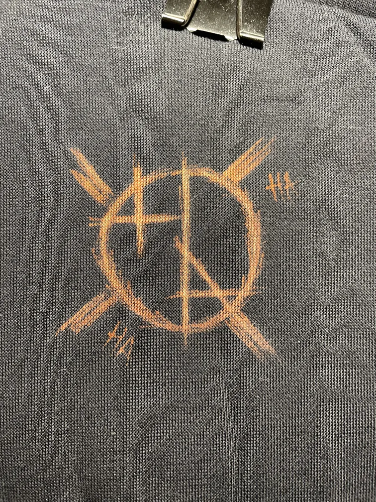 Close-up of the Helen Oben Art logo styled in a joker-inspired aesthetic on the hoodie