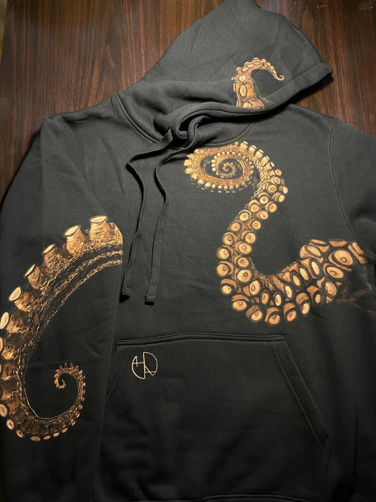 Front view of a hoodie with kraken tentacles extending across the sleeves and hood
