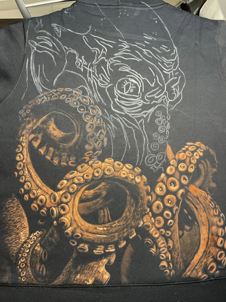 Work in progress of a kraken illustration painted with bleach on a hoodie