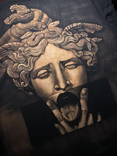 Detailaufnahme des Medusa-Gorgone-Gesichts im statueninspirierten Bleach-Art-Stil auf einem T-Shirt