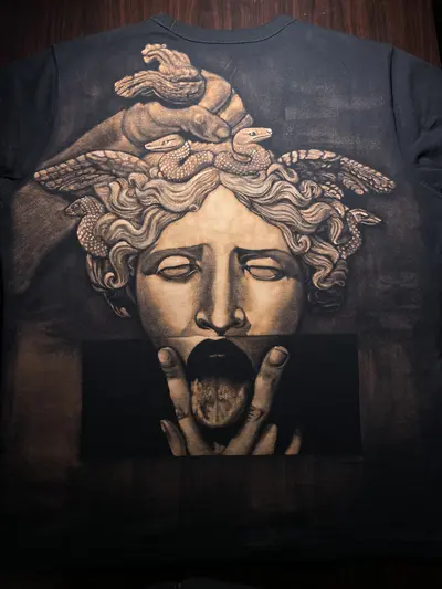 Medusa-Gorgone-Statue als Bleach-Art-Illustration über die gesamte Rückseite eines schwarzen Uniqlo-T-Shirts