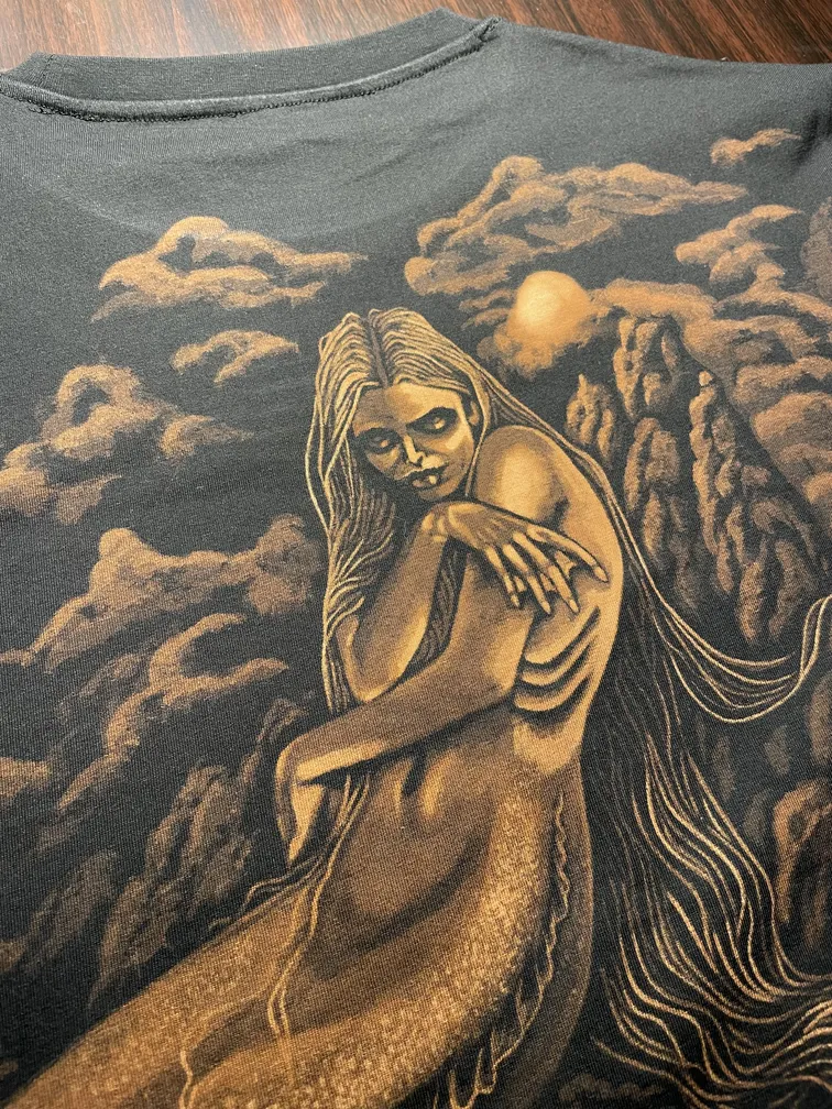 Close-up of a hand-bleached mermaid illustration with flowing hair and tail