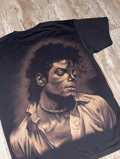 Close-up of a hand-painted Michael Jackson portrait created with bleach art on a black T-shirt