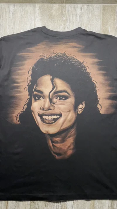 Nahaufnahme im Video vom lächelnden Michael Jackson Porträt, das mit Bleiche auf die Rückseite eines oversized T Shirts gemalt wurde