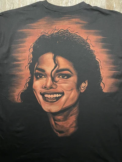 Nähere Rückansicht des lächelnden Michael Jackson Porträts, das mit Bleiche auf ein oversized T Shirt gemalt wurde