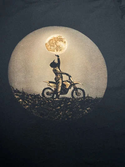 Close-up of bleach painted motorcyclist holding the moon on black T-shirt