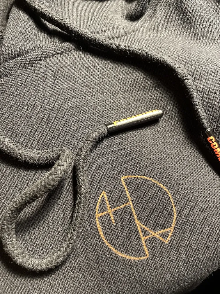 Detailaufnahme des Helen Oben Art Logos auf der Vorderseite eines Fleece-Hoodies