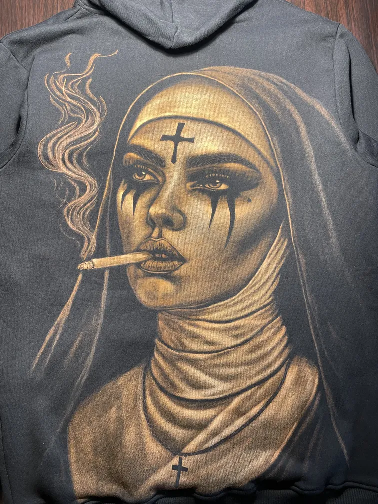 Handgebleichte Illustration einer rauchenden Nonne auf der Rückseite eines schwarzen Fleece-Hoodies