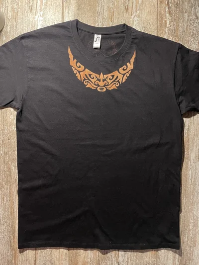 Vorderansicht des schwarzen polynesischen T-Shirts mit handbemaltem Gesichtsmotiv am Halsausschnitt