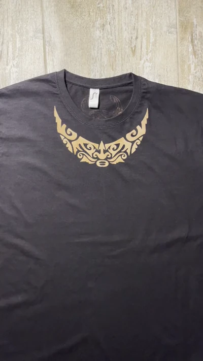 Video der vollständigen Vorderseite eines polynesischen T-Shirts mit kleinem handbemaltem Gesichtsmotiv