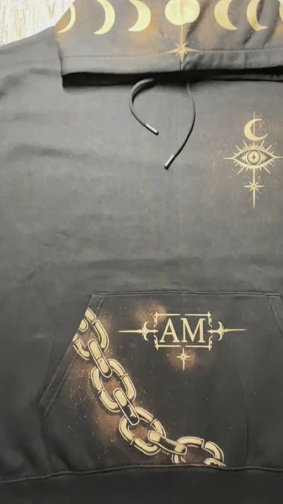 Video des vollständigen Vorderseitendesigns eines schwarzen Gothic Bleach Art Hoodies mit himmlischem Auge, Mondphasen, Initialen und Ketten