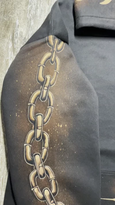 Video des handgemalten Kettendesigns auf dem rechten Ärmel eines schwarzen Bleach Art Hoodies